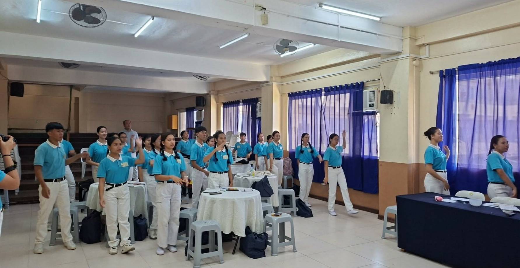 Tzu Chi Iloilo scholars follow a dance played on a screen.