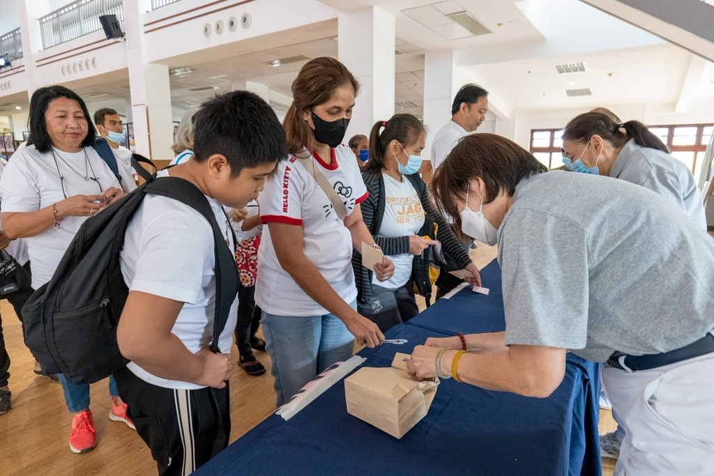 Odessa Jauod (in white shirt with red collar) claims her husband’s vitamins and medicines during the Charity Day event held last March 24.