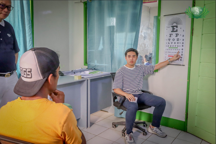 Family Eye Care nurse Angelo Santos assesses a patient’s eyesight using the Snellen chart.