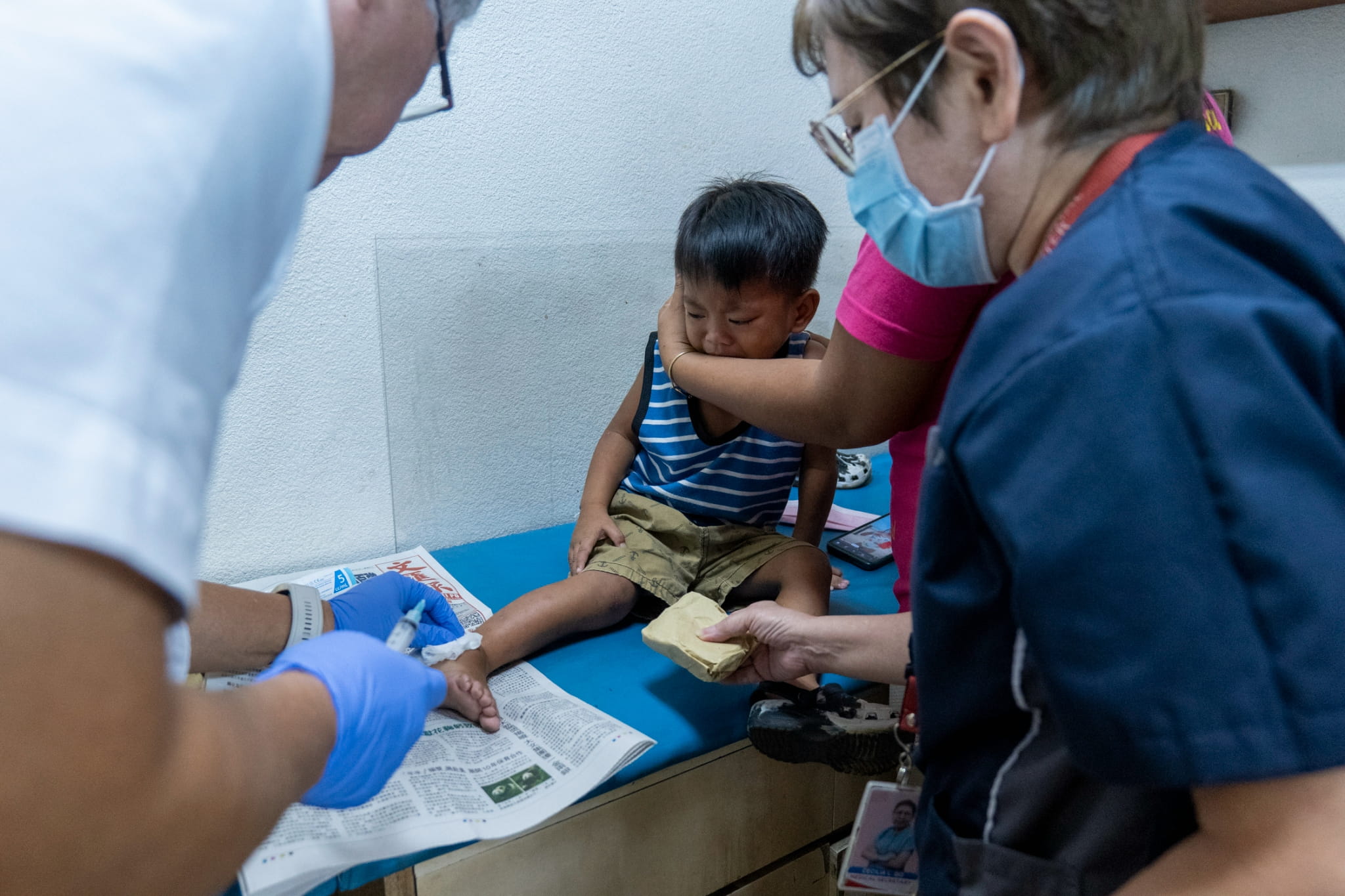 Dr. Jo Qua uses a syringe to extract a sample from the mass on Cyril Asher Aguila’s right foot for further examination and to determine its contents.