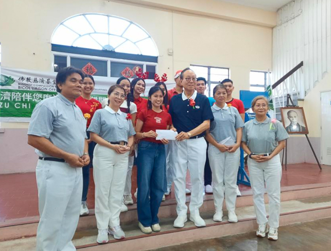 Tzu Chi Bicol volunteer Antonio “Tony” Tan hands out special prizes to raffle and contest winners at Tzu Chi Bicol’s Christmas party. 【Photo by Tzu Chi Bicol】