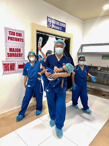 Dr. Jo Qua transfers a young patient from the operating room to the recovery room.【Photo by Tzu Chi Zamboanga】