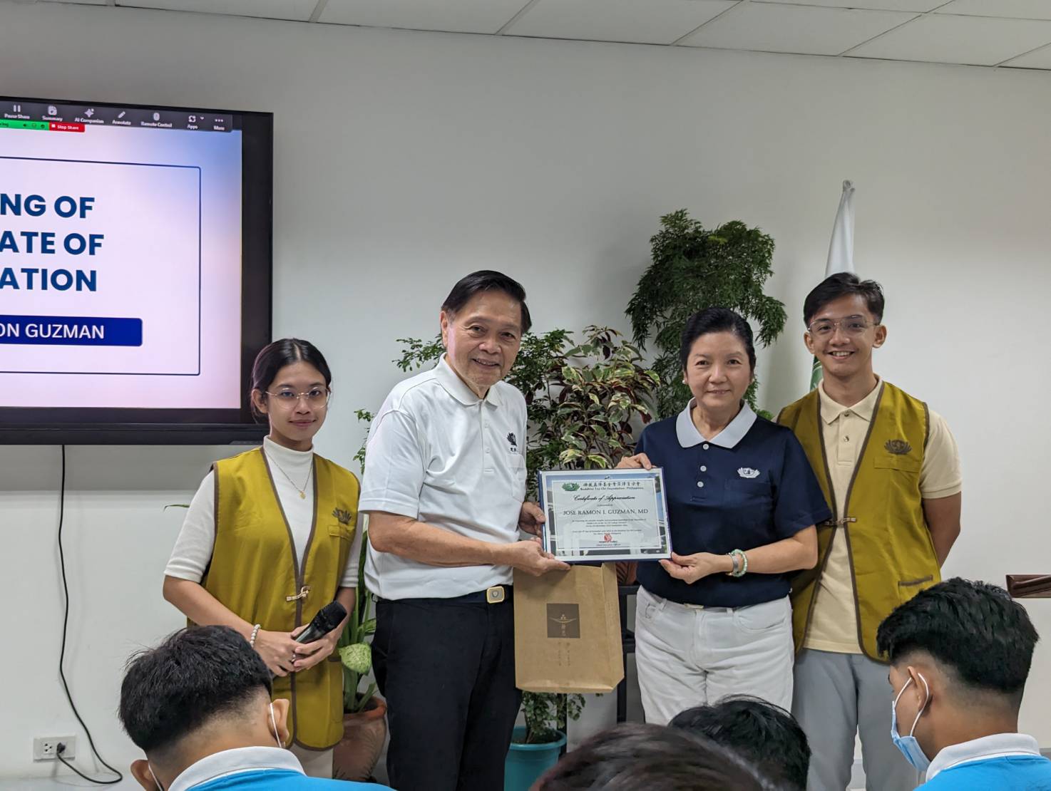  Humanity class speaker Dr. Jose Ramon L. Guzman (second from left) receives a certificate of appreciation from Tzu Chi Education Committee Head Rosa So (in blue) and Former Tzu Chi scholars Margo Ma-ang (first from left) and Jefferson Aguilar (first from right), who served as the event’s hosts.【Photo by Tina Pasion】