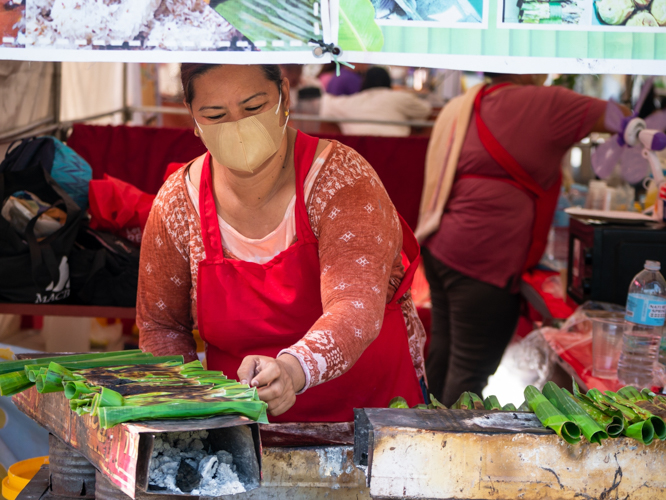 At the Kyusi Food Bazaar, a stall vendor cooks tupig, a Filipino snack made of ground, slightly fermented glutinous rice mixed with coconut milk, muscovado sugar, and young coconut strips.【Photo by Daniel Lazar】