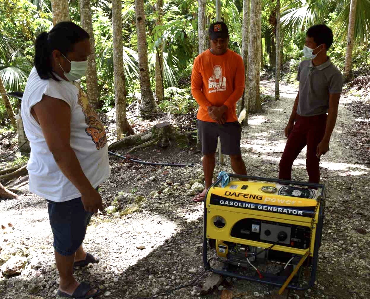 Barangay captain Marcelo Oracion (center) and his companions stand before the 7.5 kRV generator set his barangay received from Tzu Chi Foundation. 