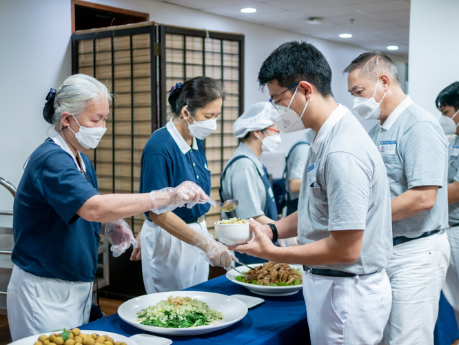 When they’re not busy cooking, kitchen volunteers serve food to participants. 【Photo by Daniel Lazar】