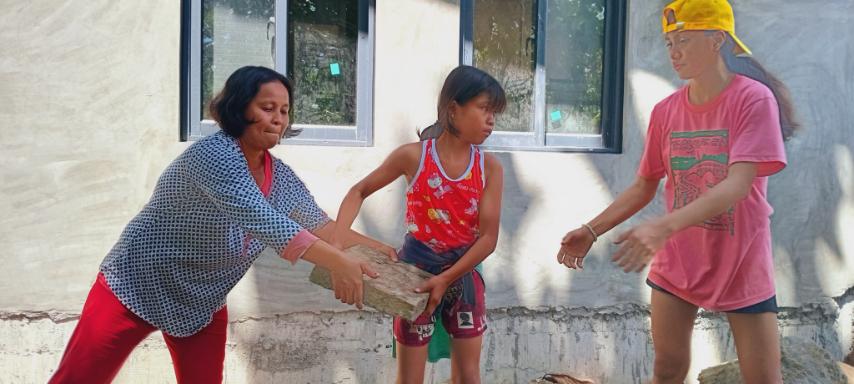 Nothing is impossible when we work together: Palo beneficiaries pass cement tiles to lay on the front of permanent homes in Tzu Chi Great Love Village. 