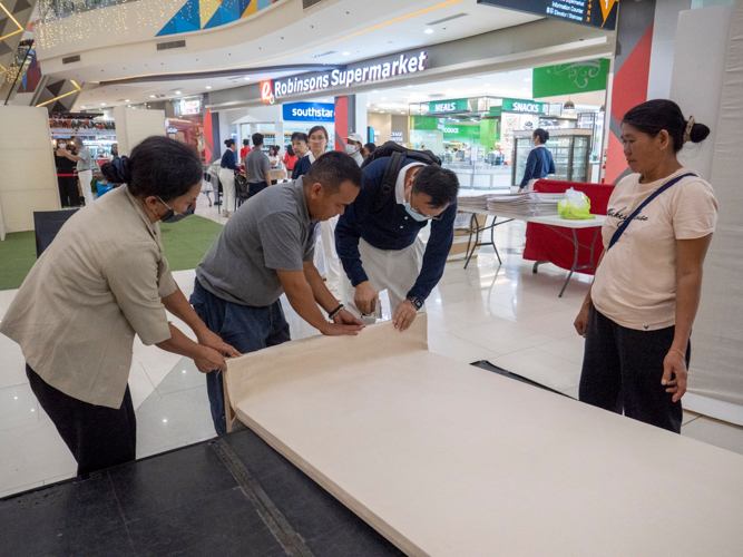 Tzu Chi volunteers set up the photo and video exhibit at Robinsons North Tacloban. 【Photo by Matt Serrano】