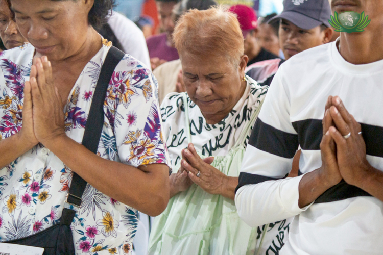 Linda Danao (center) earnestly prays, carrying with her the hope that Tzu Chi brought through their help.