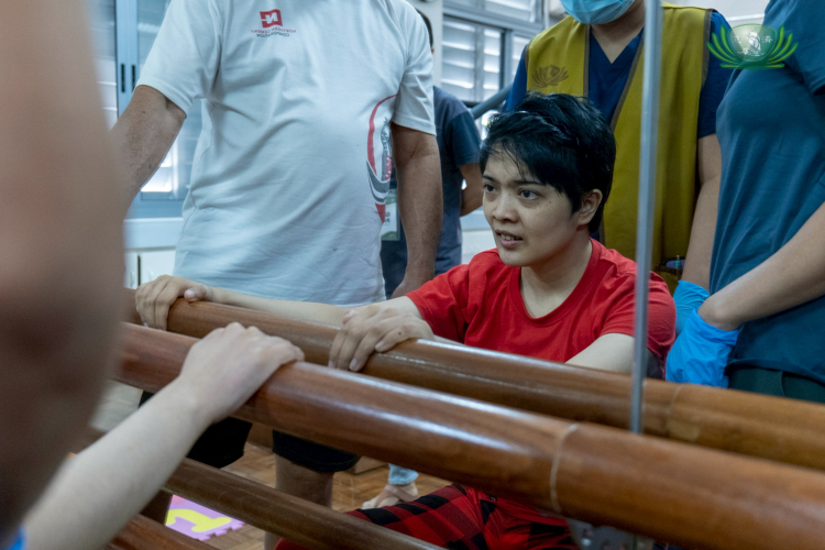 Holding on to a barre for support, Rica Serrano attempts to stand up.