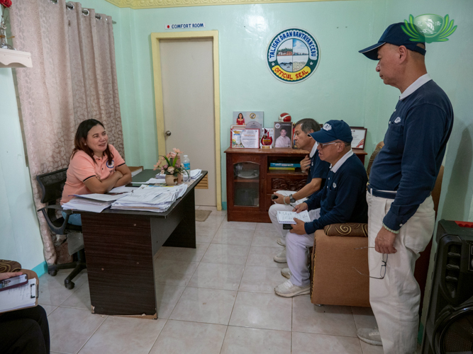 Chairperson Leilani Lahoylahoy of Barangay Talisay, Daanbantayan (left), meets with Tzu Chi volunteers before a site inspection. 
