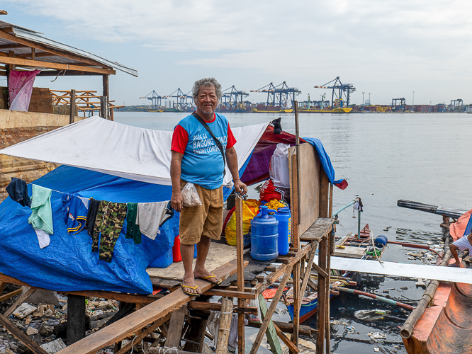 Isla Puting Bato resident Rosauro Almadin smiles despite being left with a severely damaged house. 【Photo by Jeaneal Dando】