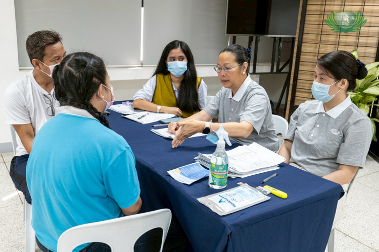 Michelle Jose (in Tzu Chi vest) watches and learns as volunteer Joy Gatdula (second from right) take the lead in a scholar’s reapplication interview. 