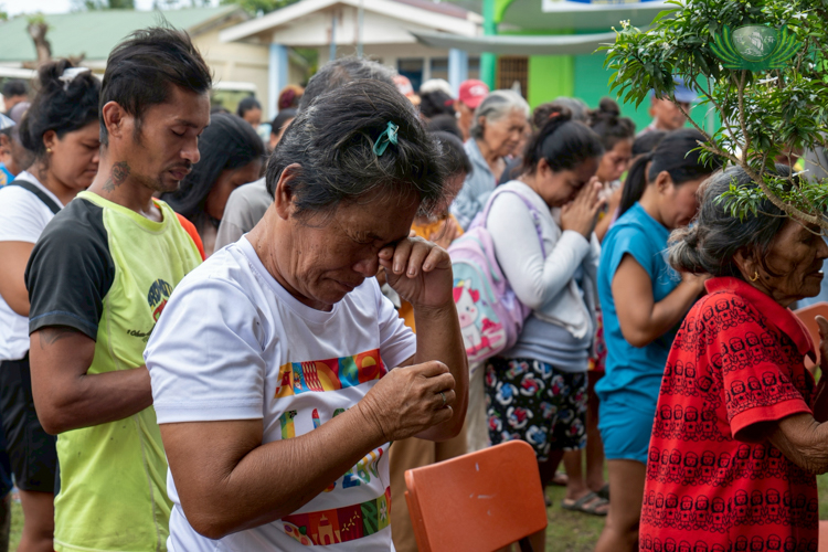 During prayer, a beneficiary is brought to tears.