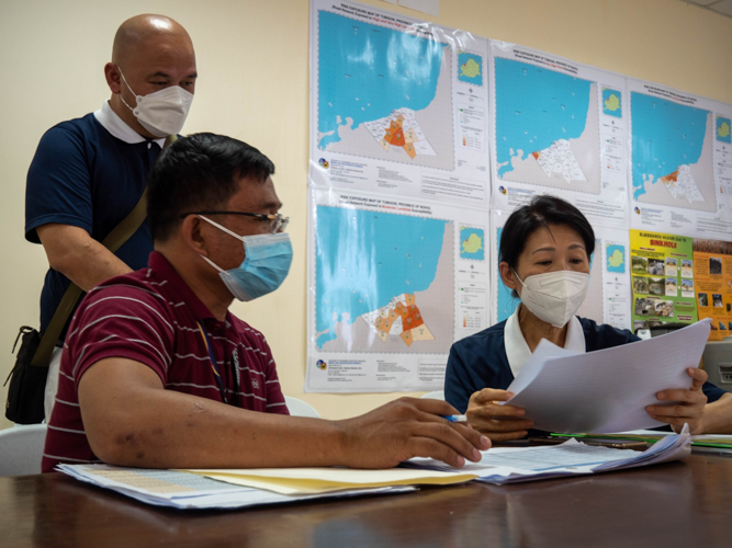 Reynaldo D. Envidiado, an officer of the Municipal Social Welfare and Development Office (MSWDO), discusses the extent of damages in Tubigon with Tzu Chi volunteers. 【Photo by Marella Saldonido】