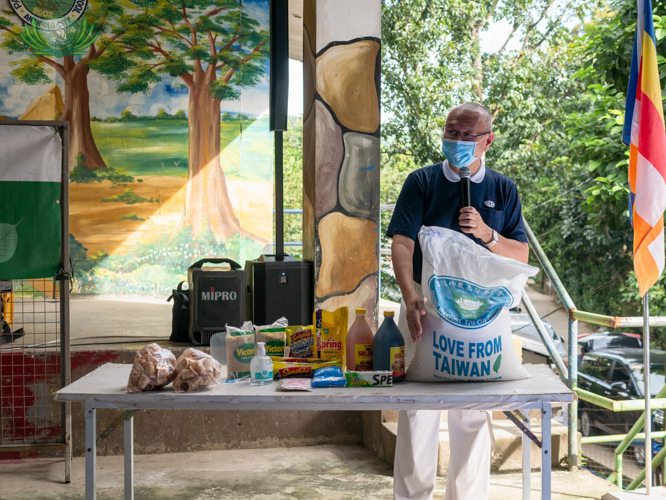 A volunteer shows beneficiaries the goods that each of them will receive—from Taiwan rice to cooking oil, vinegar, soy sauce, sugar, noodles, and bath and laundry soaps. 【Photo by Daniel Lazar】