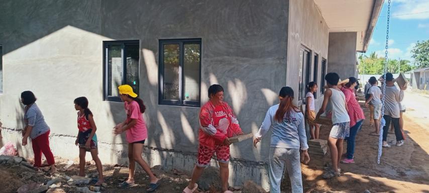 Nothing is impossible when we work together: Palo beneficiaries pass cement tiles to lay on the front of permanent homes in Tzu Chi Great Love Village. 
