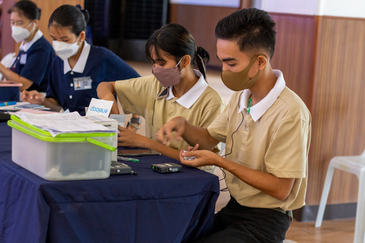 Tzu Chi beneficiaries training to become caregivers were in charge of lending out translation devices and replacing their rechargeable batteries.【Photo by Matt Serrano】