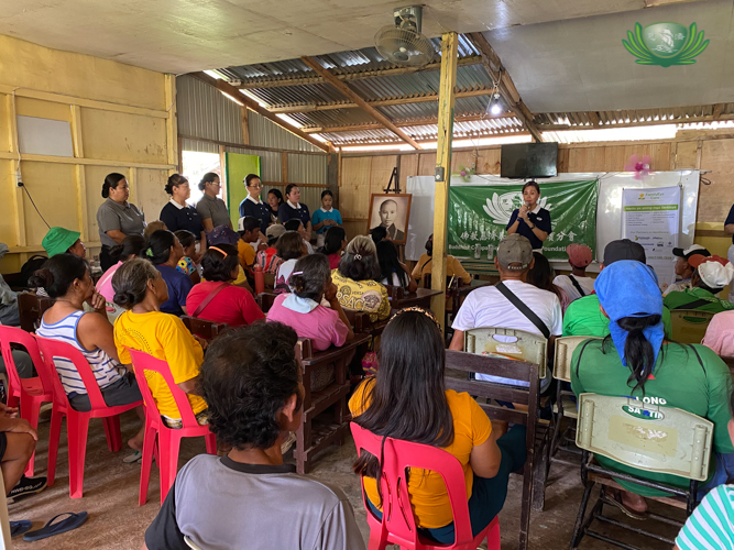 At a short program before the checkup, Tzu Chi Davao Deputy OIC Mei Yuen Ang engages Ata Manobo community members with the story of Tzu Chi Foundation and Dharma Master Cheng Yen.