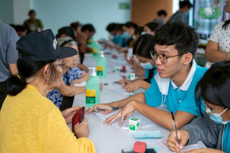 A Tzu Chi scholar assists a beneficiary in claiming relief stubs.