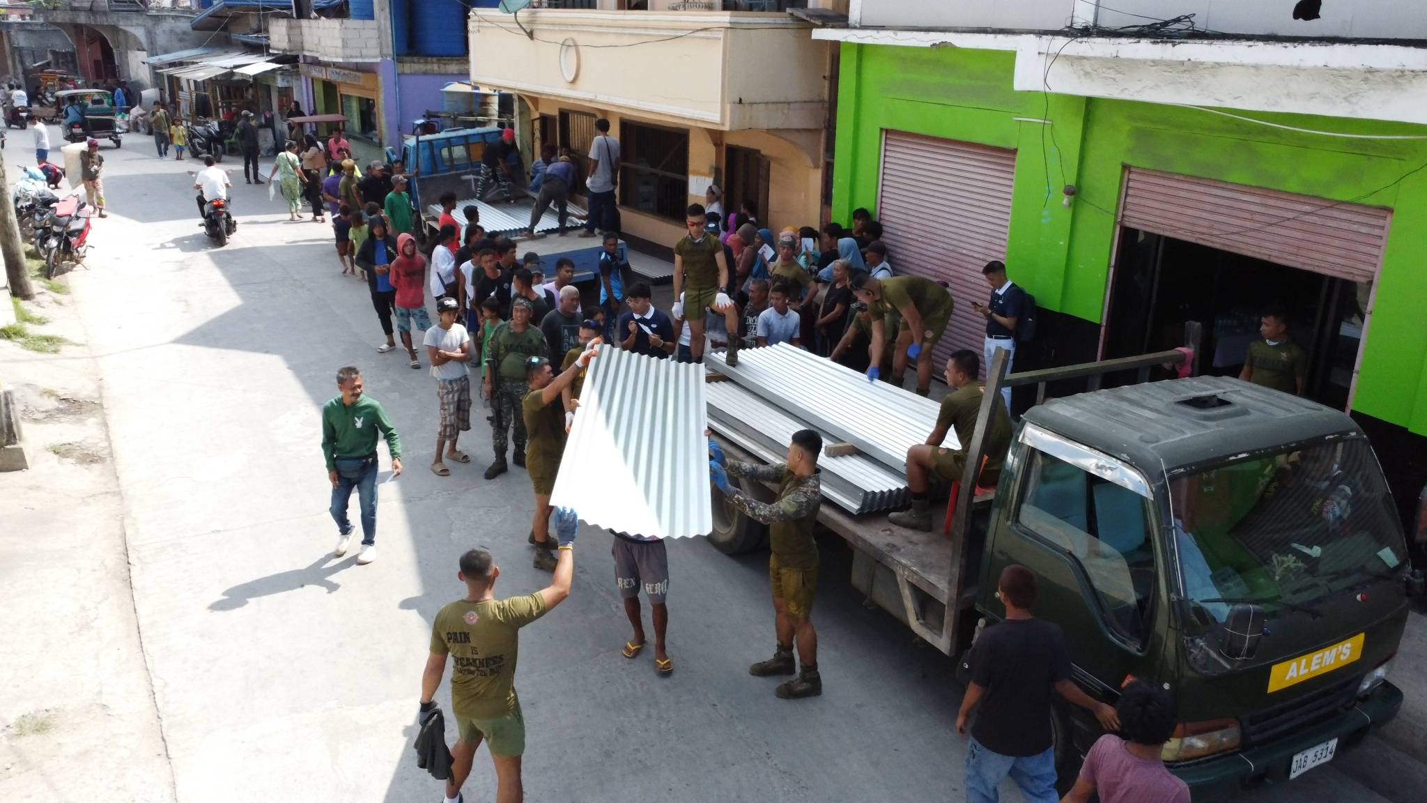 Personnel from the Philippine Navy Marines unload galvanized iron sheets.
