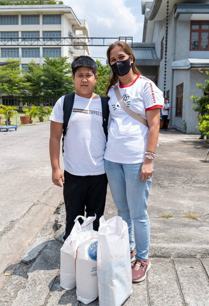 Odessa Jauod (right) and son Denver pose for a photo after receiving the groceries from Tzu Chi during the Charity Day event held last March 24.