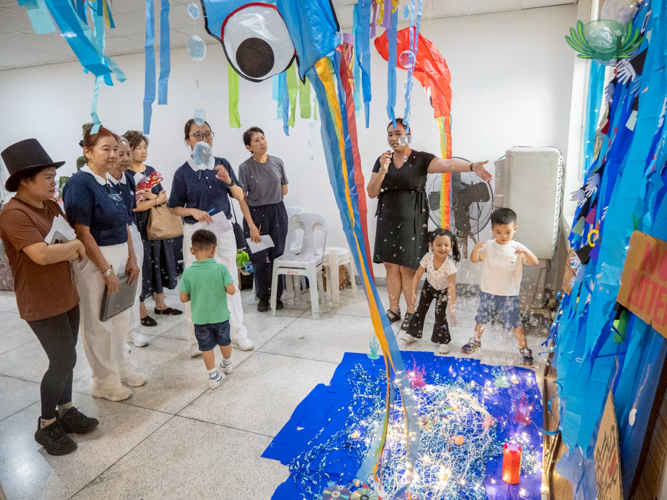 Tzu Chi volunteers (left) visit each station and grade them according to creativity and resourcefulness.