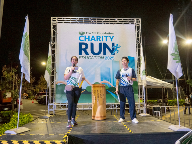 Charity Run hosts Jane Sy and Spencer Sze hype the runners while highlighting the cause of the run.