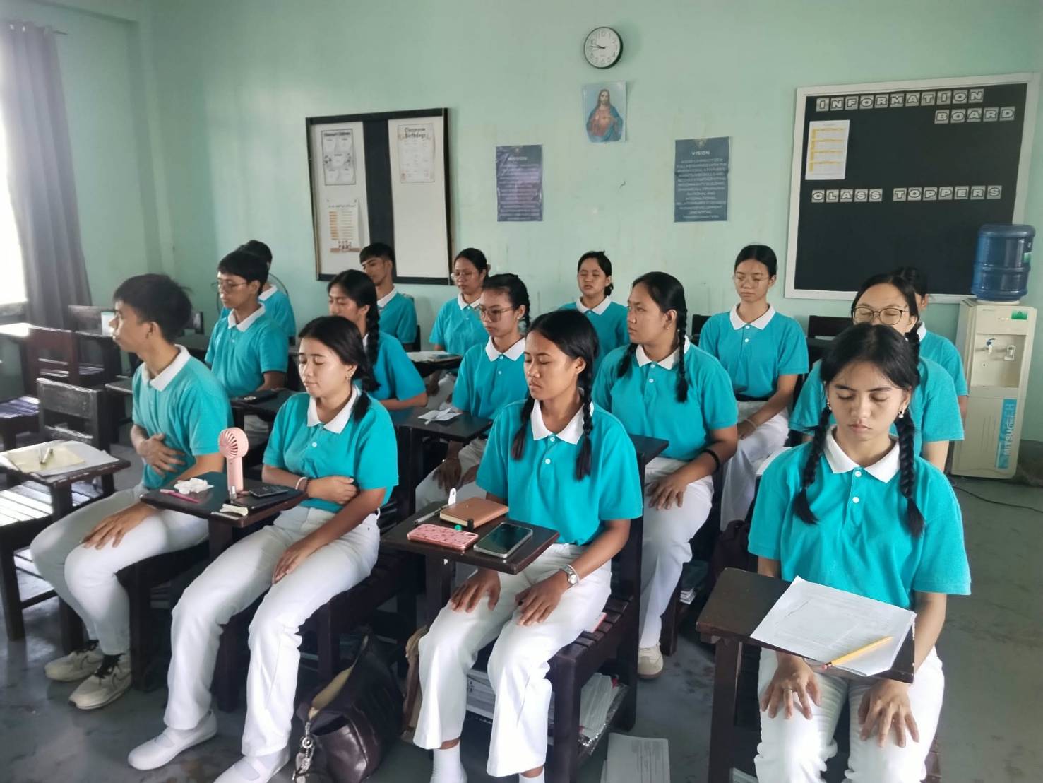 In Tzu Chi Bicol, 16 scholars sit with their eyes closed during a guided meditation.