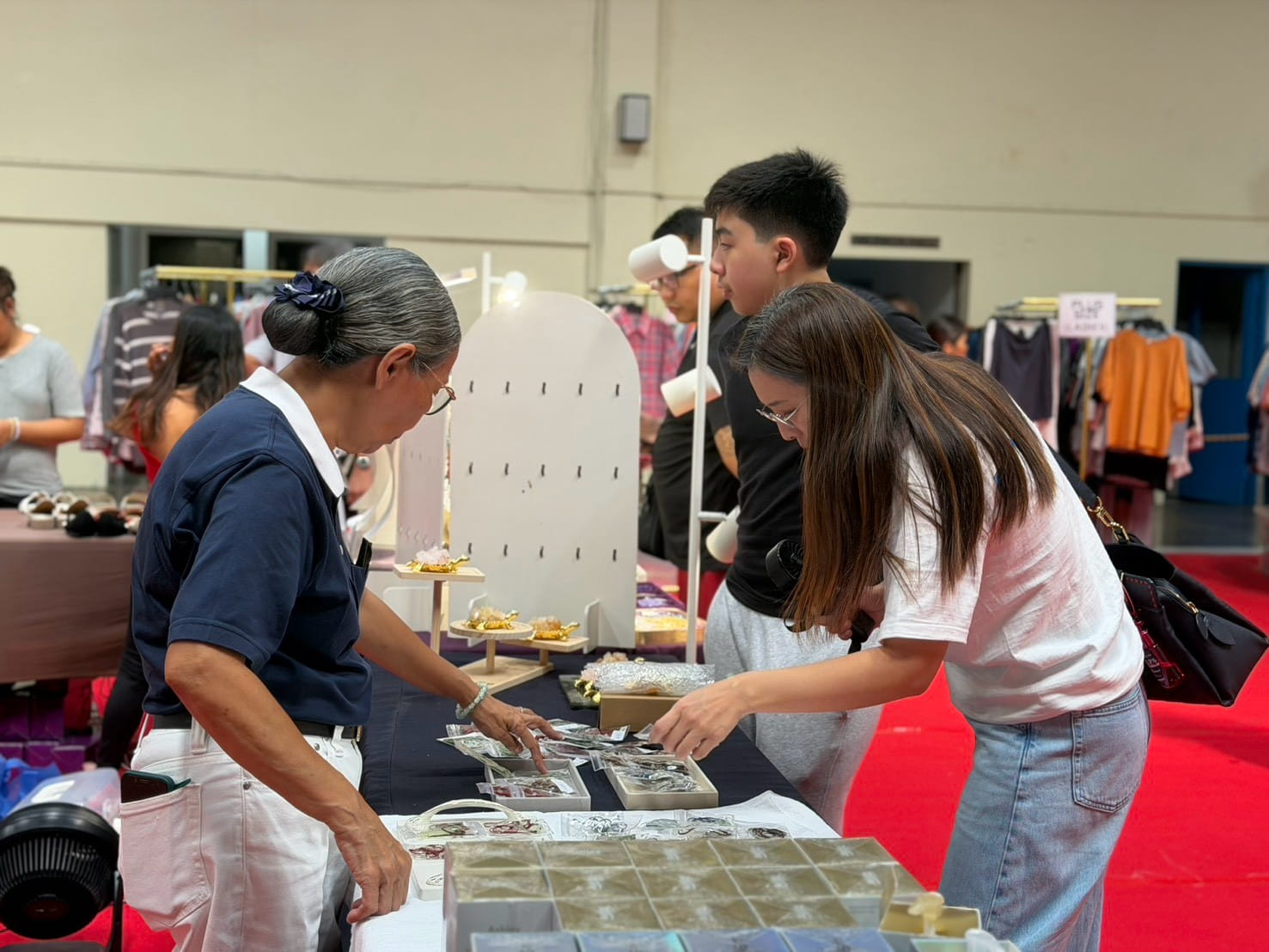 Shoppers browse a variety of items, from clothes and accessories to home essentials and toys. 