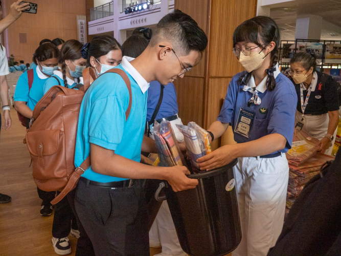 Tzu Chi Youth from Taiwan greet Filipino scholars with high fives and relief goods.