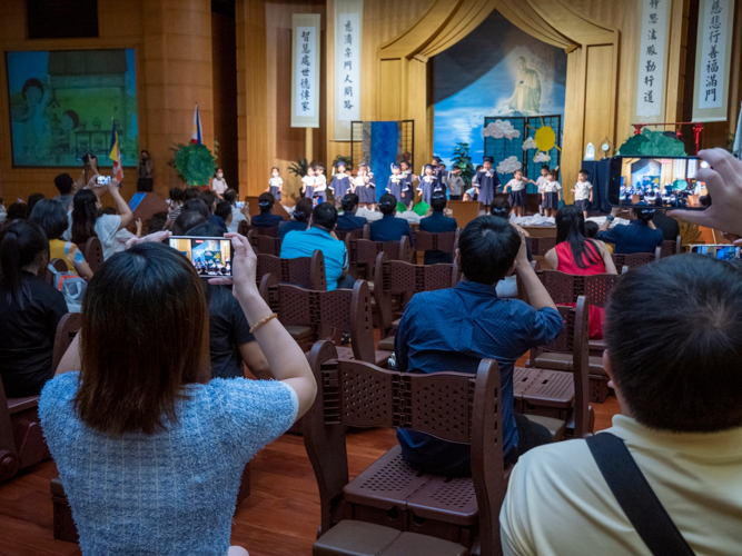 Parents take cellphone snapshots of their kids during a skit. 【Photo by Harold Alzaga】