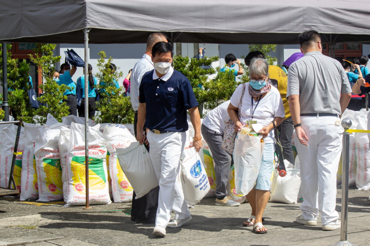 Scholars and medical assistance beneficiaries claim their 10kg sack of rice and grocery items. 【Photo by Marella Saldonido】