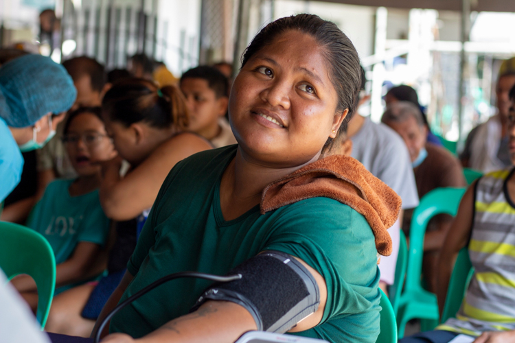Bernadette Guevara has her blood pressure taken before undergoing two tooth extractions.