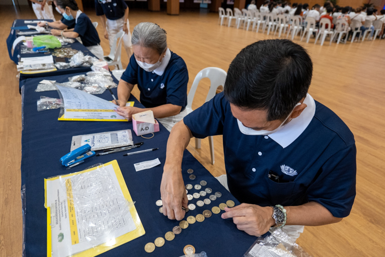 Volunteers count coin donations turned over by beneficiaries. 【Photo by Jeaneal Dando】