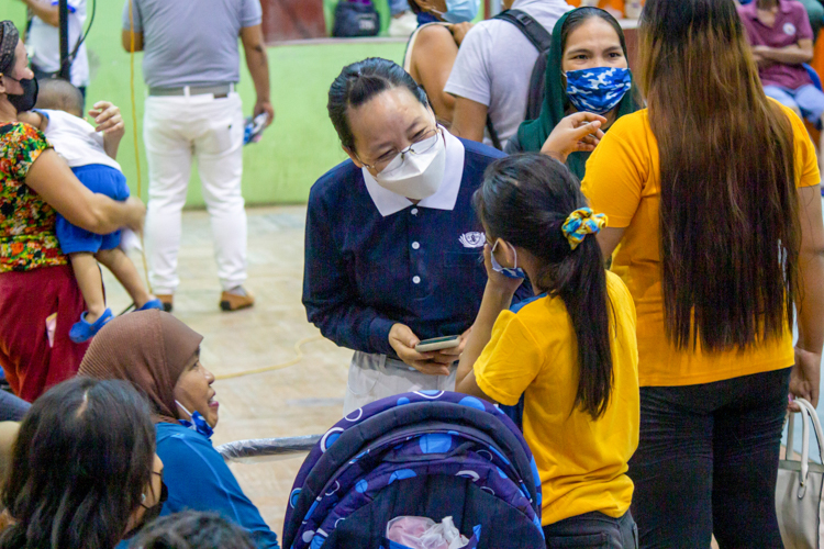 A Tzu Chi volunteer has a conversation with a patient while waiting for their turn to be seen by the doctor. 【Photo by Marella Saldonido】