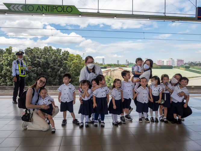 Twelve nursery kids pose with their teachers at LRT Santolan Station before embarking on their experiential learning activity.