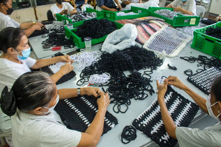 Volunteers handweave loop lines to make floor mats.【Photo by Harold Alzaga】