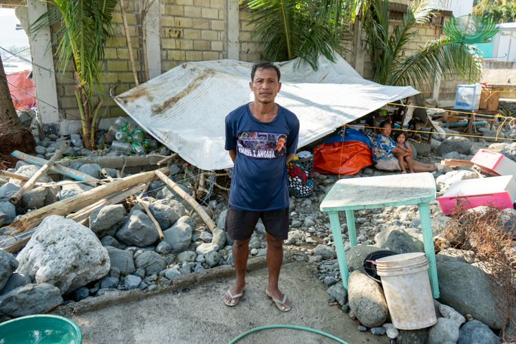 While his family is in an evacuation center, Dennis Roldan remained in the coastal area after the typhoon to continue working to provide for his family.