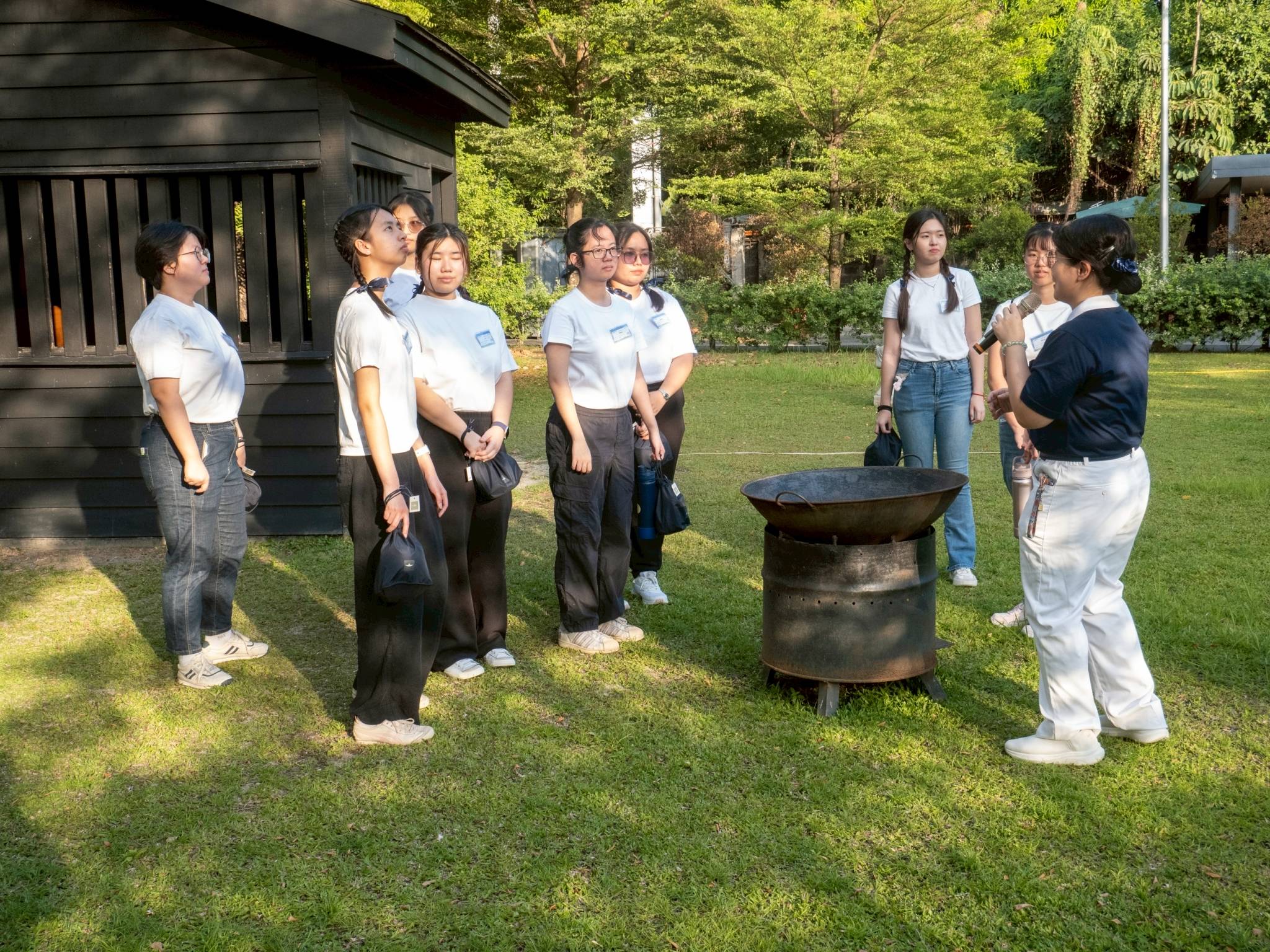 Campers stop by a replica of the wooden cabin where Dharma Master Cheng Yen lived when she first established the Tzu Chi Foundation. 