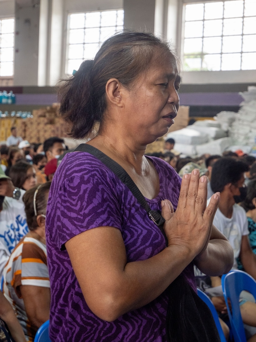 Annalee Halum, a beneficiary and mother to a Tzu Chi scholar, prays in gratitude for the generous assistance.