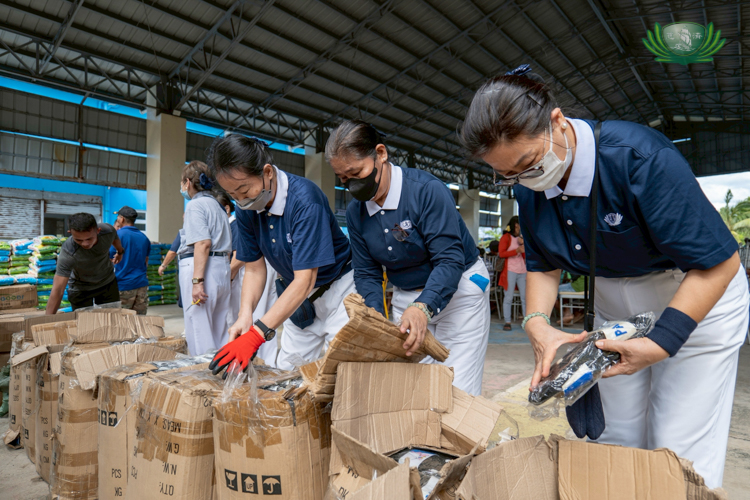 Tzu Chi volunteers carefully unpack slippers, readying them for distribution to residents of Ibona, Matawe, and Umiray.