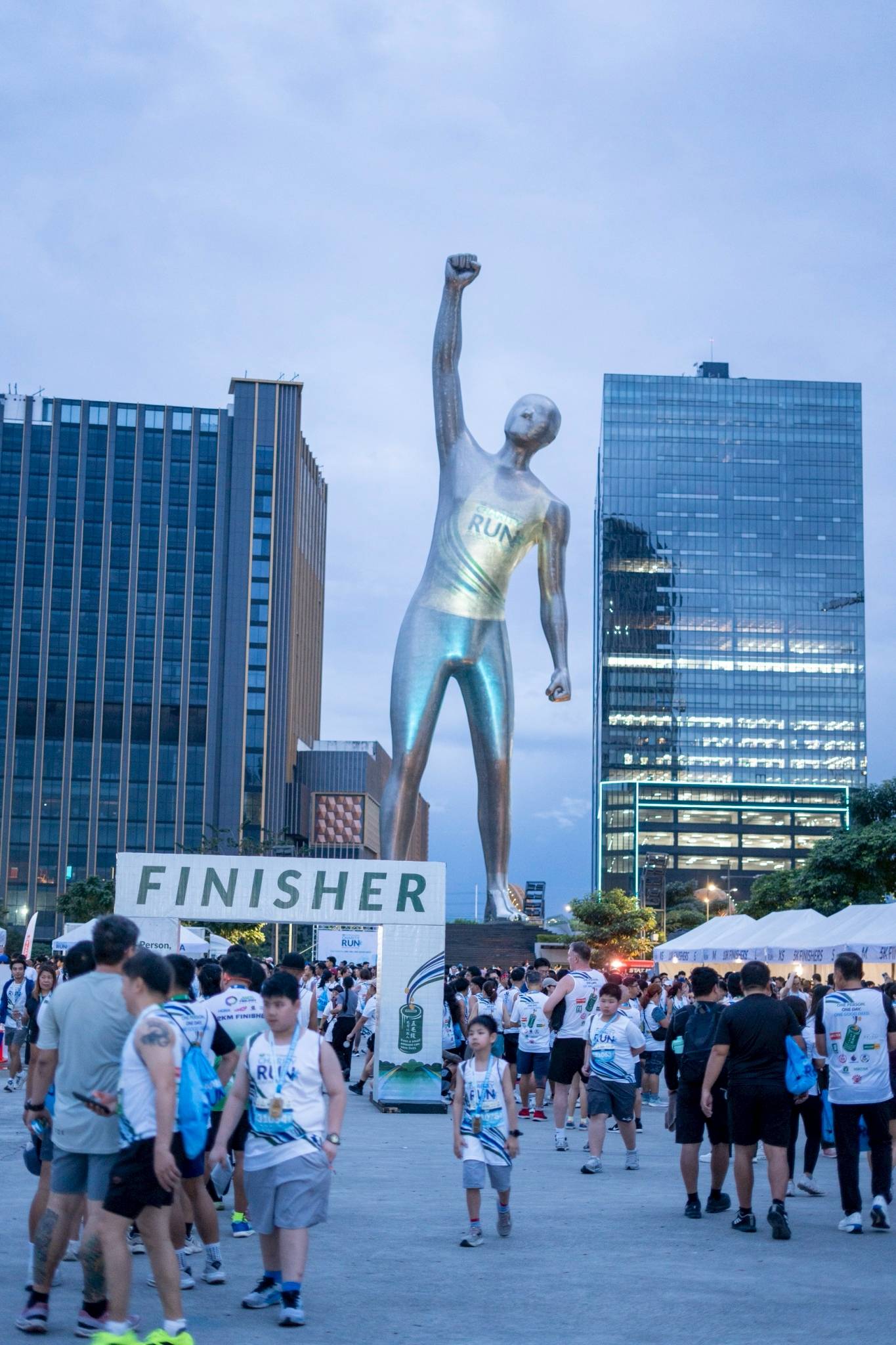 The Victor, reputed as the world’s tallest lighting projector (at 55 meters), looms over runners enjoying a post-run stroll around the Race Village in Bridgetowne Destination Estate. 