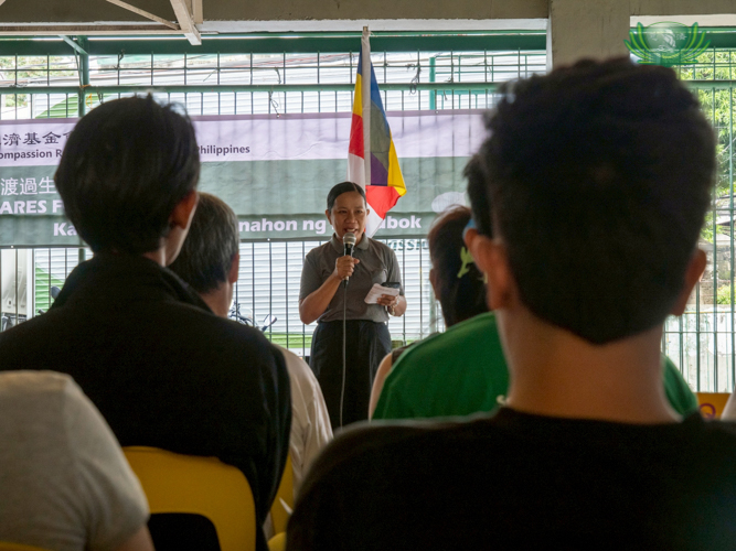 Tzu Chi staff member Julie Collado gives words of encouragement to beneficiaries, reminding them that there is hope to start over after this difficult time.