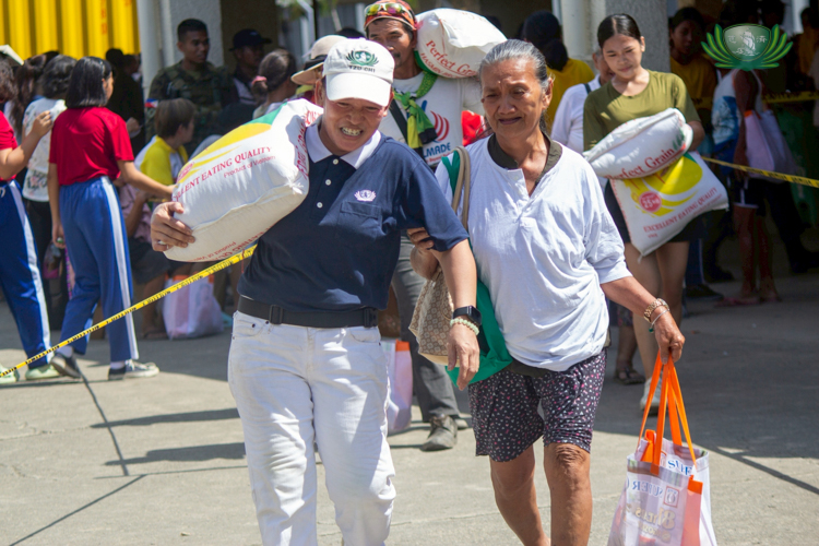 For Tzu Chi volunteers, help extends all the way to carrying a 25-kg sack of rice for beneficiaries.
