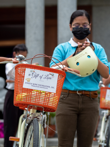 nnifer Camal prepares to wear the safety helmet that came with the bicycle.【Photo by Matt Serrano】