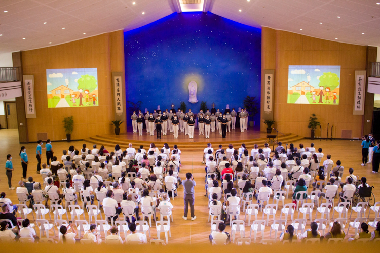 Volunteers and scholars lead beneficiaries to sing and sign the songs “One Family” and “Prayer.”【Photo by Matt Serrano】