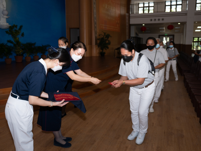 Volunteer receive angpao, a red envelope symbolizing good luck and prosperity. 【Photo by Daniel Lazar】