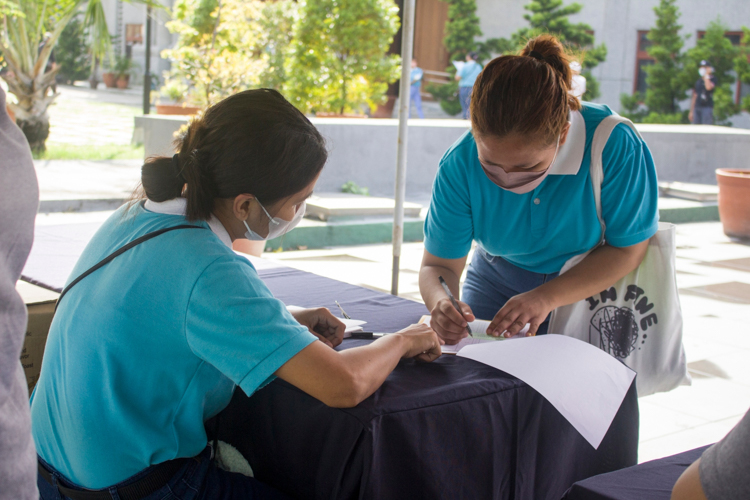 One of 294 scholars signs in at the May 21 rice relief distribution morning session at the Buddhist Tzu Chi Campus in Sta. Mesa, Manila. 【Photo by Matt Serrano】