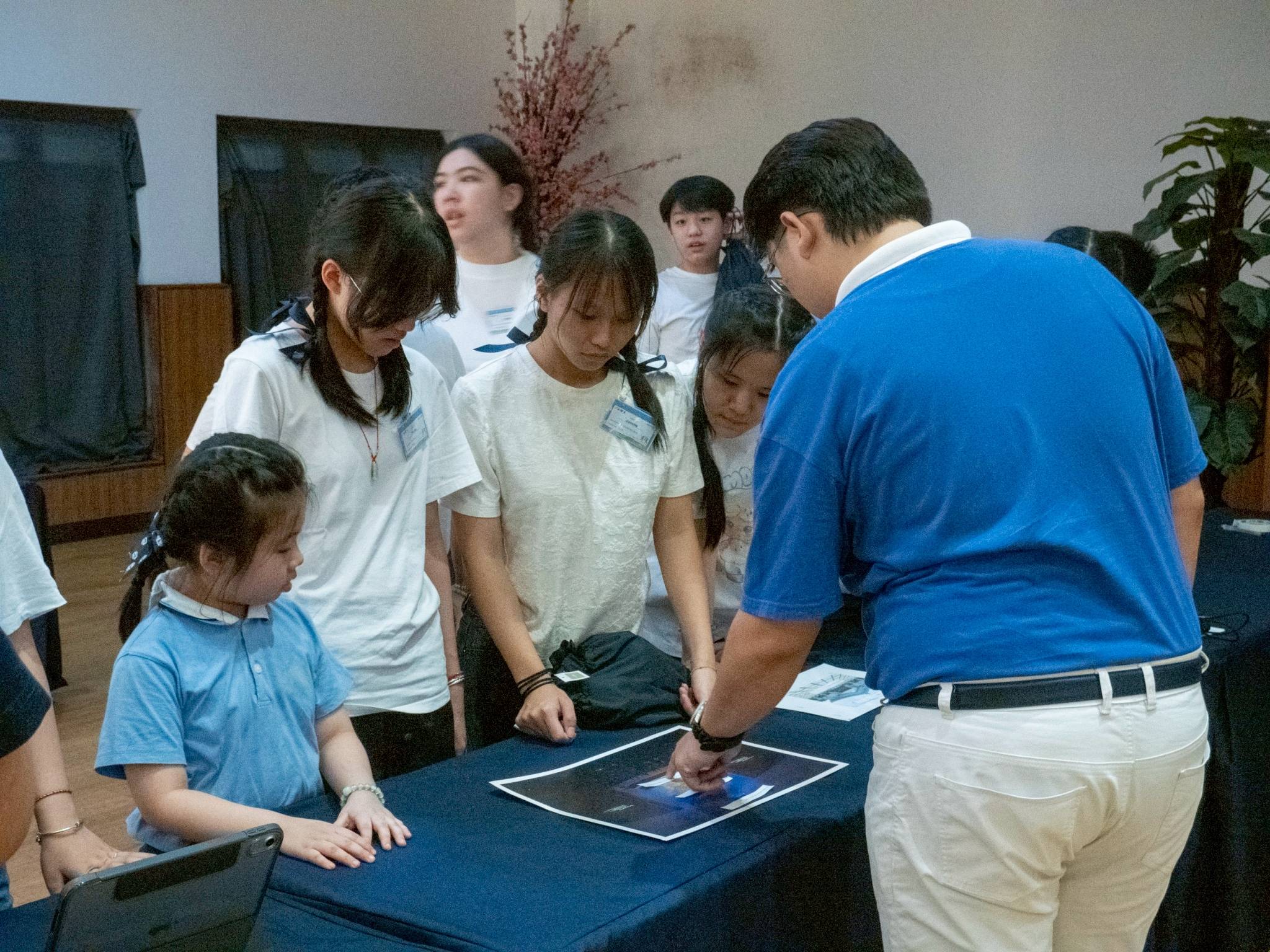 At the Jing Si Hall, a TCY member explains the relevance of the auditorium’s architectural details to campers. 